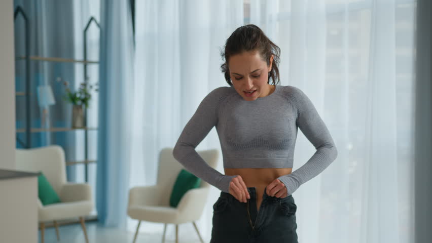 Dissatisfied sad Caucasian woman girl female obese weight wearing jeans overweight body shape fatty figure size fat upset slimming bad result diet obesity eating disorder problem sport training home