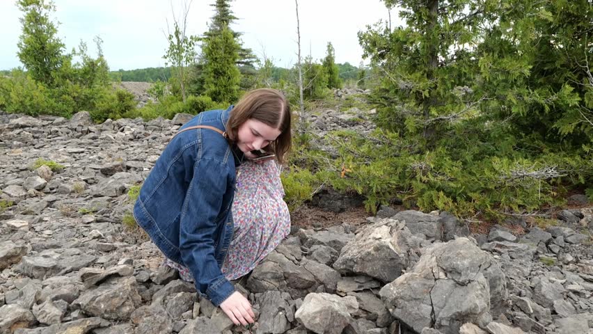 A Teen Girl Looks Through Rocks for Fossils at a Michigan Park