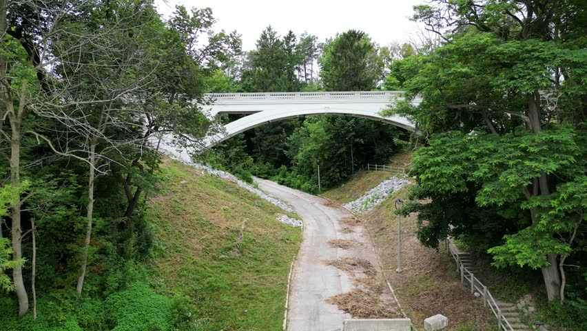 Newly Rehabilitated Concrete Arch Footbridge In Lake Park Is Known To Be The Crown Jewel Of Milwaukee, Wisconsin. 4K Aerial Approaching The White Landmark Bridge.