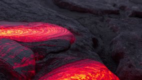 Streams of bright red and orange lava flow through cracks in black volcanic rock, creating mesmerizing swirling patterns as the molten material moves. - Powered by Shutterstock - Get 15% off with code: PIKWIZARD15