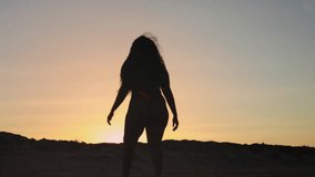 Curly black woman on beach. Plus size model on beach feeling positive about her body and not considering herself fat. Self-acceptance concept. Silhouette of dark-skinned girl on beach. - Powered by Shutterstock - Get 15% off with code: PIKWIZARD15
