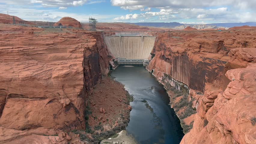 View of Glen Canyon Dam and the Colorado River from the overlook on Highway 89 in Page, Arizona, USA. Showcasing the impressive scale of the dam and the beauty of the surrounding red rock canyon.