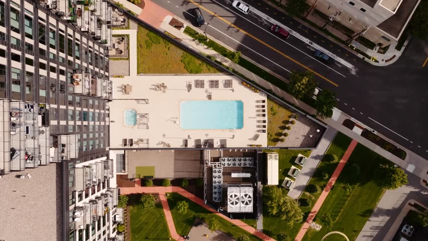 top down aerial drone shot of an outdoor pool attached to a high rise condo building
