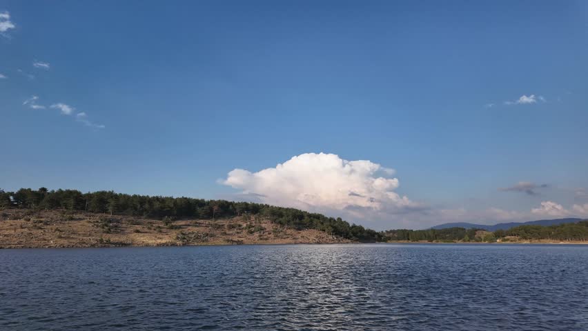 Scenic Timelapse of Lake with Majestic Cloud Movements. people canoeing on the lake