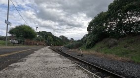A quiet train station in a small country town showcases empty platforms and serene surroundings under a cloudy sky. - Powered by Shutterstock - Get 15% off with code: PIKWIZARD15
