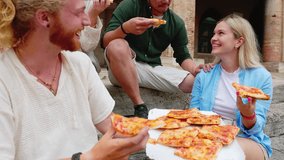 Young people eating pizza at city street. Millennial young group of multiracial tourist friends eating take away pizza sitting together at town square while enjoying summer vacation in Italy.  - Powered by Shutterstock - Get 15% off with code: PIKWIZARD15