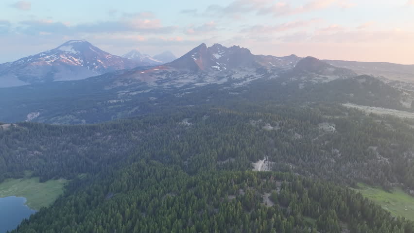 A summer sunrise illuminates the landscape around Three Sisters mountains, Oregon. These mountains and their surrounding forests, near Bend, provide exceptional hiking, biking, climbing, and camping.