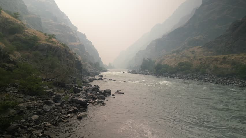 Low aerial above Snake River in Hells Canyon Idaho with hazy wildfire smoke