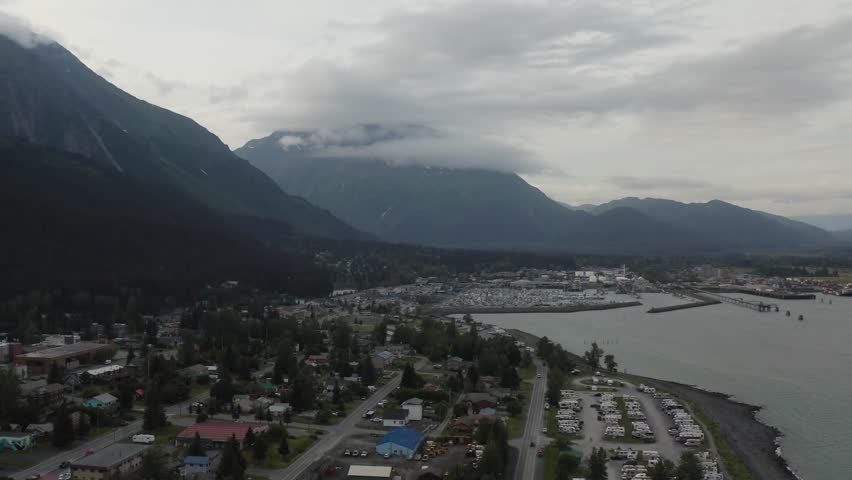 Aerial view of downtown Seward, Alaska with harbor port and town with Resurrection Bay and mountain landscape - 4K Drone