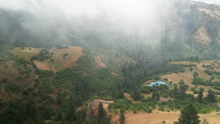 Aerial of low clouds above mountains in White Bird Idaho in summer