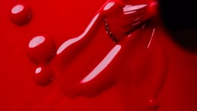 Red nail polish drops, manicure concept. Spilled uv gel, enamel, varnish with brush on red color background, splash. Beauty salon, nail care product. Nail art. Top view, fashion backdrop. Slow motion  - Powered by Shutterstock - Get 15% off with code: PIKWIZARD15