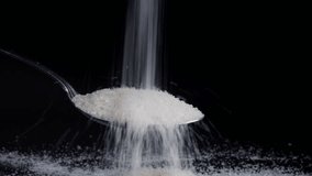 pouring sugar onto spoon isolated black background - Powered by Shutterstock - Get 15% off with code: PIKWIZARD15