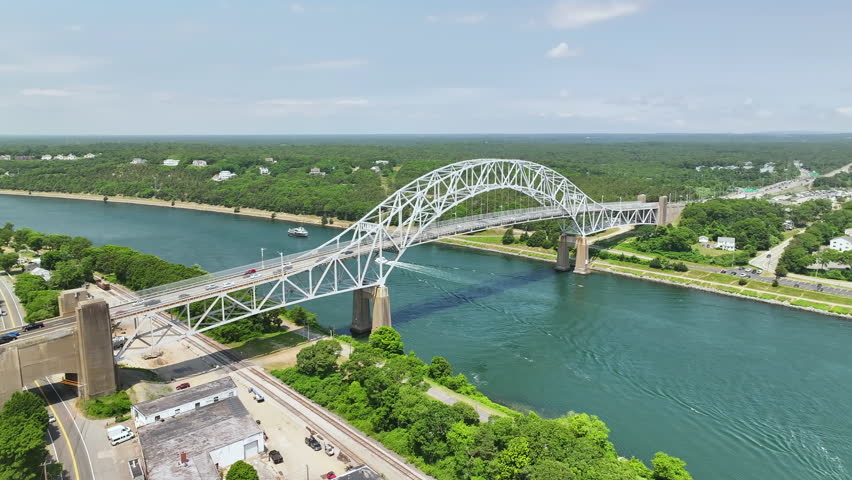 The sagamore bridge spanning a river on a sunny day in cape cod, aerial view