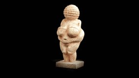 Venus of Willendorf statue Replica rotating over black background - looping video