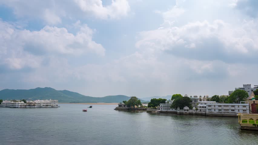 4K Time lapse of clouds moving in sky at Lake Pichola and Udaipur city. Monsoon clouds over beautiful old architecture of Udaipur, Rajasthan, India. Scenic timelapse of Lake Pichola in morning.
