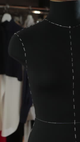 Empty black mannequin in the background light is in the middle of the studio. Cute toy in the form of dresses hanging on a rope. Shop Dummy. Fashion Designer Clothes Maker Draping Dummy In Studio