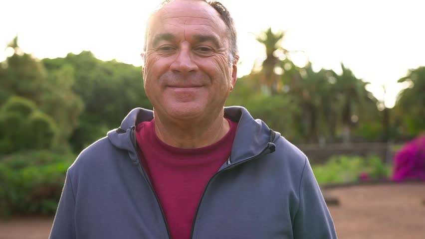 Fit senior man smiling on camera during sunset time at city park after running routine - Healthy elderly lifestyle and sport concept  - Powered by Shutterstock - Get 15% off with code: PIKWIZARD15