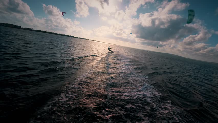 Young man kite surfing. Extreme kite boarding in slow motion. Summer fun action sports. Happiness in nature