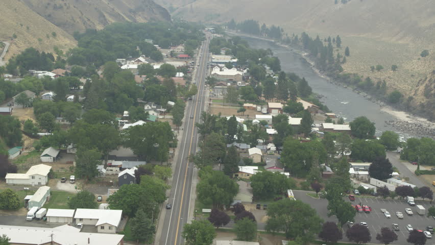 Aerial of small town of Riggins Idaho next to Salmon river on hazy summer day