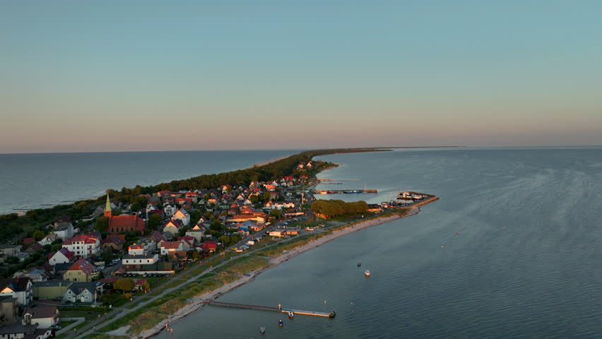 Aerial view of Kuźnica, Poland, highlighting the charming coastal town during sunset. The town