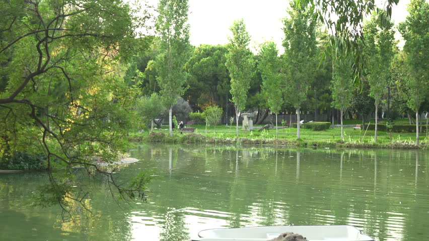 Beautiful green park and lake, white boats in Antalya, Turkey