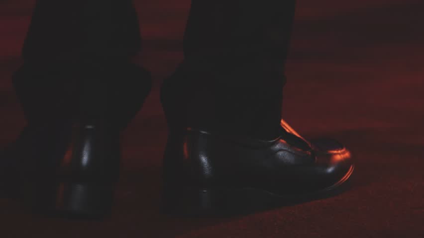 Dancing shoes of a couple, couples dancing traditional latin argentinian dance milonga in the ballroom, tango salsa bachata kizomba lesson, festival on wooden floor, purple, red and violet lights