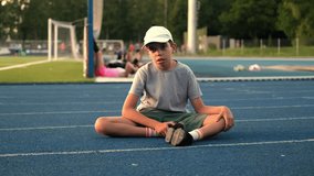 boy sits, runner falls, children's sports, runner, family gets involved in sports, workout, warm-up, sports, treadmill, football players, football field, game, childhood, teenagers - Powered by Shutterstock - Get 15% off with code: PIKWIZARD15