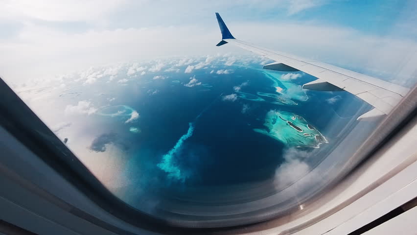 Airplane flies over the islands in the Maldives