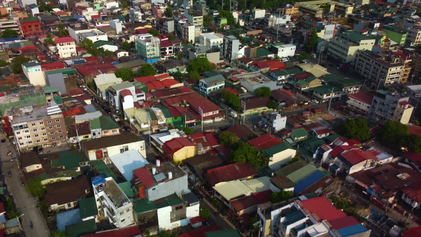 Drone flying over the vibrant homes of Makati city, sunny morning in Philippines