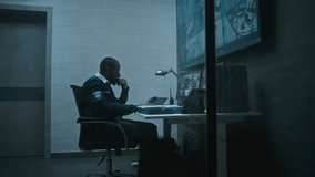 African American male CCTV operator controls office surveillance cameras using computer, works in modern monitoring center. Multiple monitors and big digital screen showing security video footage. - Powered by Shutterstock - Get 15% off with code: PIKWIZARD15