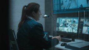 Female surveillance operator controls security cameras with face recognition in monitoring center using computer, talks on landline phone. CCTV footage on multiple monitors and big digital screen. - Powered by Shutterstock - Get 15% off with code: PIKWIZARD15