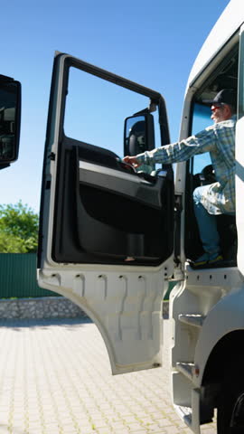 Professional senior truck driver sits in his truck. Vertical video