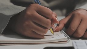 Closeup mixed race businesswoman hands making notes in notebook at workplace. Unknown female entrepreneur writing schedule in diary book.  arms crossing text in notebook - Powered by Shutterstock - Get 15% off with code: PIKWIZARD15