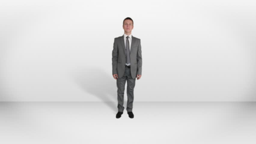Businessman in white room approaching camera and touching an invisible screen