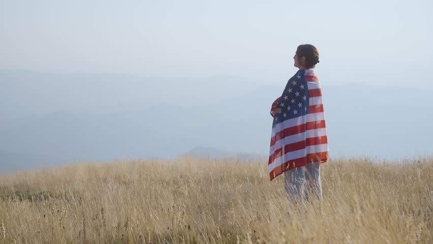 Woman with American flag on a Mountain peak