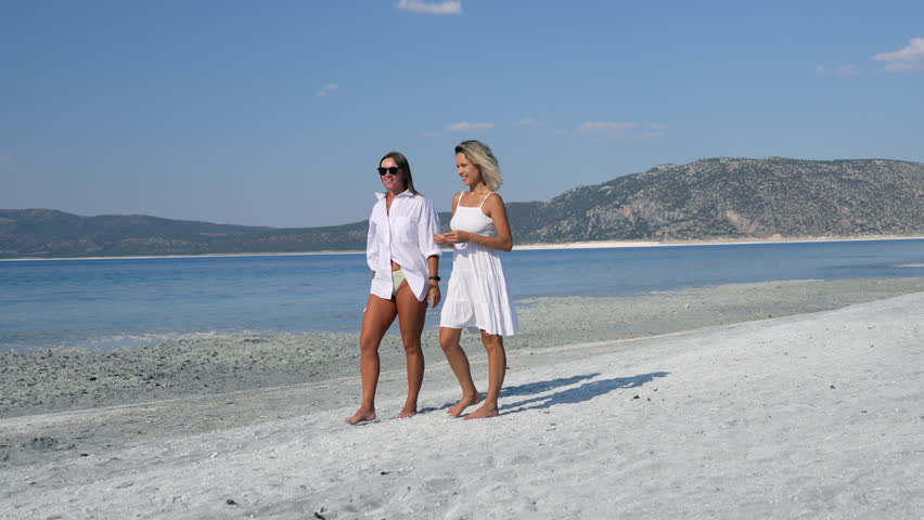 Two female walking at the beach 