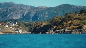 A small settlement on the rocky forest-covered shores of the Norwegian fjord. Tilt-shift video. - Powered by Shutterstock - Get 15% off with code: PIKWIZARD15