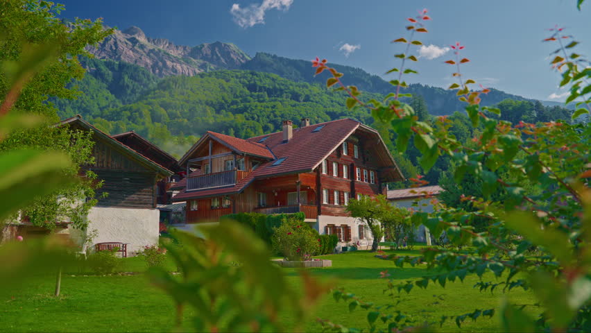 Establishing shot of the beautiful Swiss nature and village in Switzerland. Footage of idyllic swiss village sunny day. Wide view of Swiss Alps. Switzerland summer tourism destination