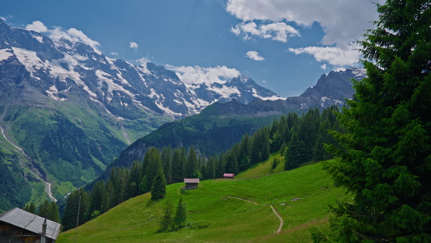 Establishing shot of the beautiful Swiss nature and village in Switzerland. Footage of idyllic swiss village sunny day. Wide view of Swiss Alps. Switzerland summer tourism destination