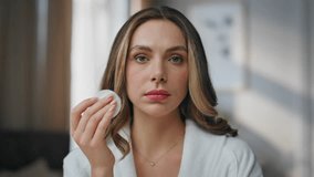 Morning woman cleaning face in bathroom pov view. Gorgeous model rubbing skin with cotton disposable pad doing everyday routine closeup. Satisfied lady removing impurities and makeup at home interior - Powered by Shutterstock - Get 15% off with code: PIKWIZARD15