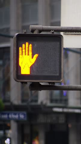 A vertical view of a walk don't walk sign on a street in New York City.  	