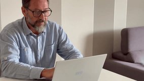 Man working from home, sitting at the table with a laptop, looking focused and worried. Concept of remote work, modern small business, and telecommuting. Home office setup, representing digital and on - Powered by Shutterstock - Get 15% off with code: PIKWIZARD15