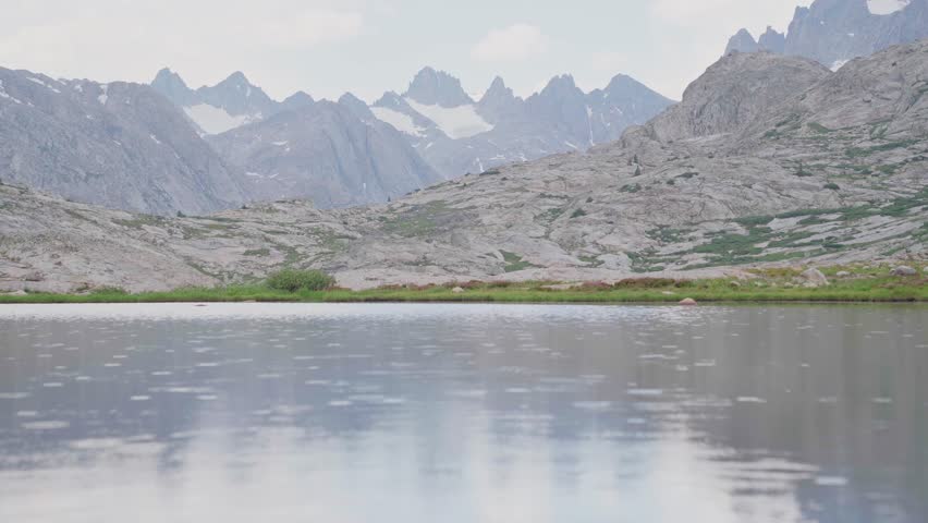 Rain sprinkles on pristine Titcomb Basin lake in Wind River Range Wyoming