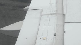 view to aeroplane's wing with flap operation to neutral position after landing arriving to airport while taxi to arrival terminal hall,transportation holiday vacation - Powered by Shutterstock - Get 15% off with code: PIKWIZARD15