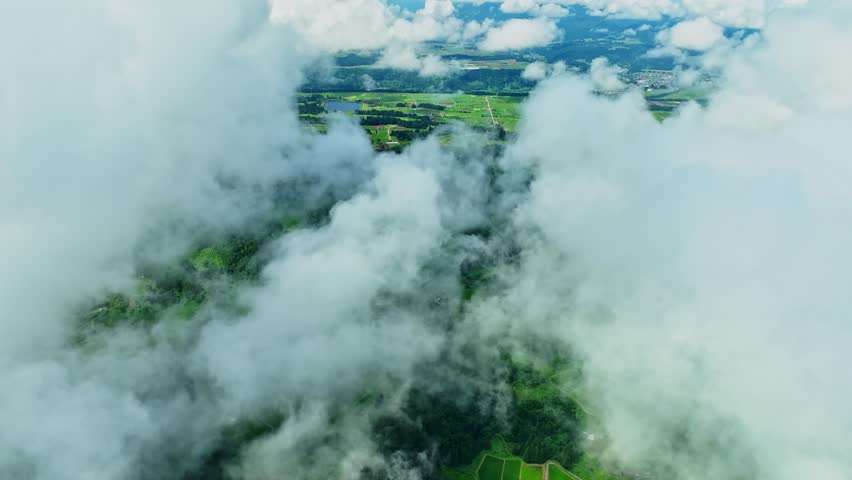 Drone footage: A large amount of clouds covering the mountains in the countryside