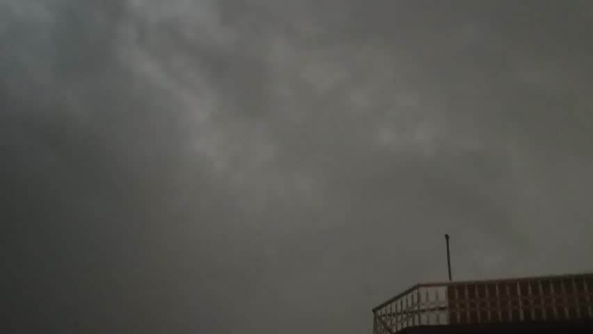 Lightening ocsurs in the sky and heavy dark clouds all around 