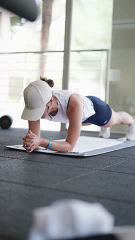Female athlete hold plank as abs exercise at indoor gym facility, Spain