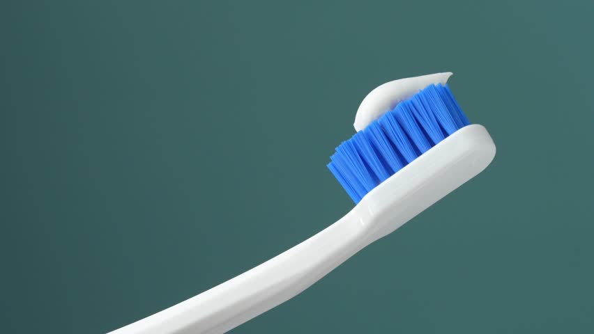 White toothbrush with toothpaste on a blue background. Hygiene. Professional photo.