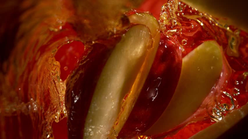 Super Slow Motion Shot of Red Apple Cuts Followed by Camera Splashing into Juice at 1000 fps.