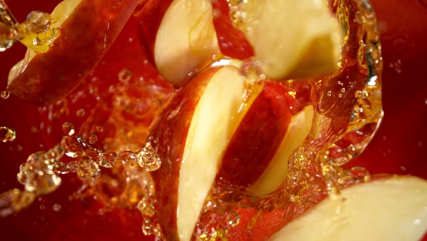 Super Slow Motion Shot of Red Apple Cuts Followed by Camera Splashing into Juice at 1000 fps.